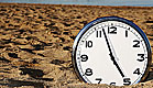 שעון מכוון כמעט על השעה 5 ,מונח על החול בים (צילום: mako  ,jupiter images)
