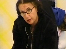שרה לוין יושבת על המיטה