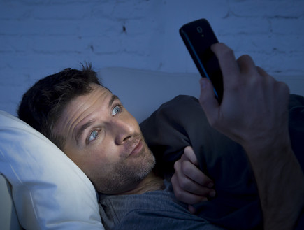 אילוסטרציה: גבר צופה בסמארטפון (צילום: ShutterStock)