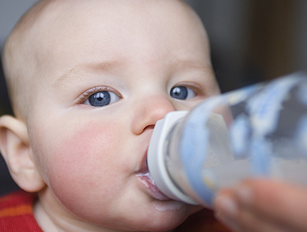תינוק שותה מבקבוק ומביט למצלמה (צילום: jupiter images)