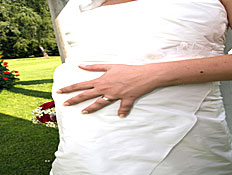 כלה בהריון מניחה יד על הבטן שלה (צילום: jupiter images)