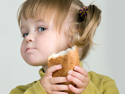 ילדה קטנה בירוק אוכלת באגט (צילום: Dainis Eglavs, Istock)
