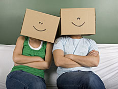 זוג יושב עם ארגזי קרטון וחיוך מצויר על הראש (צילום: kutay tanir, Istock)