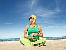 אישה בהריון יושבת על חוף הים (צילום: abu, Istock)