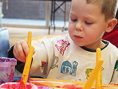 ילד יושב ומצייר ציור עם מכחולים וצבעים (צילום: Acik, Istock)