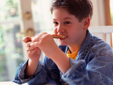 ילד בז'קט ג'ינס אוכל משולשי פיצה (צילום: jupiter images)