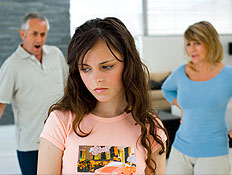 נערה עצובה בורוד וברקע הוריה עומדים כועסים (צילום: jupiter images)