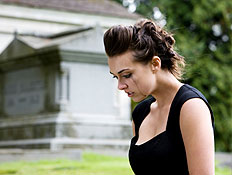בחורה בשחור בוכה וברקע קבר (צילום: quavondo, Istock)