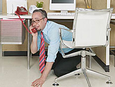 בחור מדבר בטלפון,מסתתר מתחת לשולחן (צילום: jupiter images)