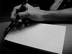 יד מחזיקה עט מול פנקס לבן חלק (צילום: stock_xchng)