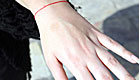 יד מושטת,עונדת צמיד אדום של קבלה (צילום: עודד קרני)