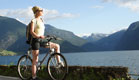 בחורה על אופניים ליד אגם (צילום: Shutterstock)