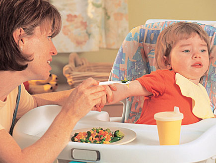 אמא מנסה להאכיל בירקות את ילד סרבן בכיסא (צילום: jupiter images)