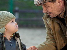 זקן וילד בכובע מחזיקים ידיים ברחוב ומסתכלים זה על זה (צילום: jupiter images)