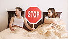 גבר ואישה במיטה הגבר מחזיק תמרור עצור ביניהם (צילום: jupiter images)