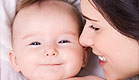 קלוז אפ של אישה מצמידה פניה לתינוק מחייך (צילום: snapphoto, Istock)