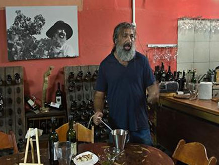 יקב יהודה-אדם מבוגר עם זקן,מאחוריו בקבוקי יין