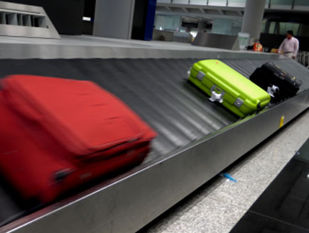 מסוע מזוודות עם שלוש מזוודות עליו