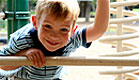 יום כיף: ילד מציץ מבעד לברזלים של מתקנים בגן שעשוע (צילום: Steve Debenport, Istock)