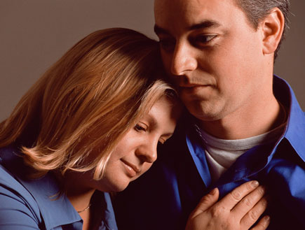 אמון 2- זוג בחולצות כחולות ופנים עצובות מחובקים (צילום: jupiter images)