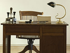 שולחן עבודה עתיק מעץ ועליו מנורה וניירות לידו כיסא (צילום: xavigm, Istock)