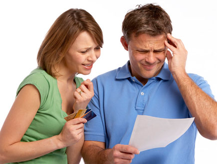 איש בכחול תופס ראש ונייר ביד אישתו מבוהלת עם אשראי (צילום: jupiter images)