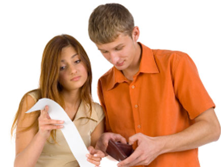 הבחור בודק את הארנק והבחורה עם החשבון לידם עגלת קנ (צילום: Tomasz Trojanowski, Istock)