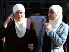 נשים ערביות בכיסוי ראש השמאלית בטלפון