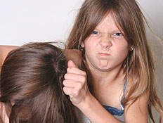 ילדה בפרצוף כועס מושכת בשיער לילדה אחרת