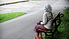 קשישה יושבת על ספסל (צילום: ilbusca, Istock)