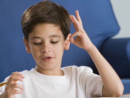 ילד עושה שעורים ומחשב בידיים ליד ספה כחולה (צילום: jupiter images)