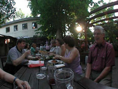 אנשים יושבים לאורך שולחן עץ בטברנה וינאית (צילום: אור גץ)