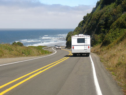 קרוון נוסע על כביש עם נוף של ים (צילום: iStock)