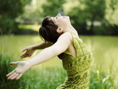 יציאה לחופשה - אישה בשמלה ירוקה בשדה ירוק (צילום: iStock)