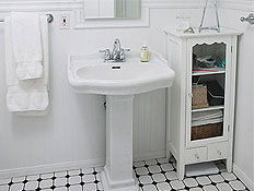 חדר אמבטיה מעוצב בלבן עם ריצוף משובץ, ארונית, מראה