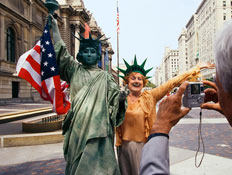 תיירת מצטלמת ליד דמות של פסל החירות