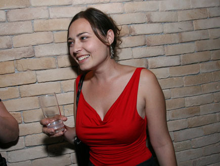 מירה עוואד- בשמלה אדומה מחזיקה כוס ביד