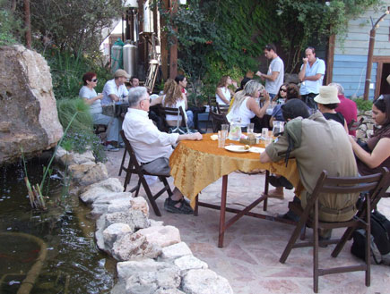 אנשים יושבים בבית קפה גבנה לשולחן עם מפה זהובה (צילום: איל שפירא)