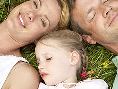 הורים לילדים - אבא אמא וילדה שוכבים על הדשא (צילום: jupiter images)