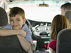 ילד קטן במושב האחורי של מכונית מחייך