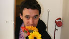 בחור מחזיק פרחים בפתח דלת (צילום: איתי בוטבגה)