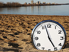 שעון מכוון כמעט על השעה 5 ,מונח על החול בים (צילום: אור גץ)