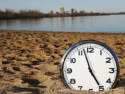 שעון מכוון כמעט על השעה 5 ,מונח על החול בים (צילום: אור גץ)