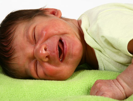 תינוק בוכה על שמיכה ירוקה (צילום: Jaimie Duplass, Istock)