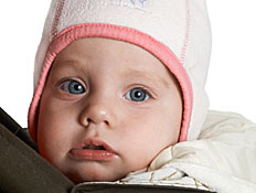תינוק עם עיניים כחולות בכובע ורוד ולבן (צילום: istockphoto)