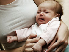 תינוק בוכה בידי אמו (צילום: Nikolay Suslov, Istock)