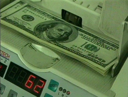 מכונה לספירת כסף עם שטרות של 100 דולר (תמונת AVI: חדשות1 ערוץ 2)