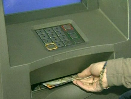 אישה מוציאה כסף מכספומט (תמונת AVI: אור גץ, חדשות)