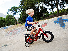 ילד בלונדיני רוכב על אופניים אדומות (צילום: Don Bayley, Istock)
