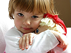 ילדה בקארה מחבקת בובה (צילום: Reno12, Istock)
